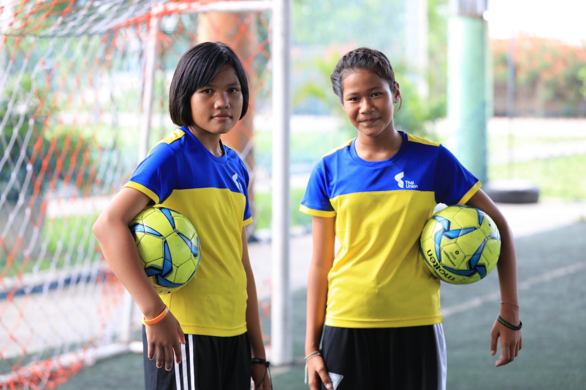 Nichada Hanchengchai, left, and Jennapa Maksawat, both sixth-grade students at Wat Yaichomprasat School, are pictured during a football clinic organized by Thai Union and Samut Sakhon Football Club